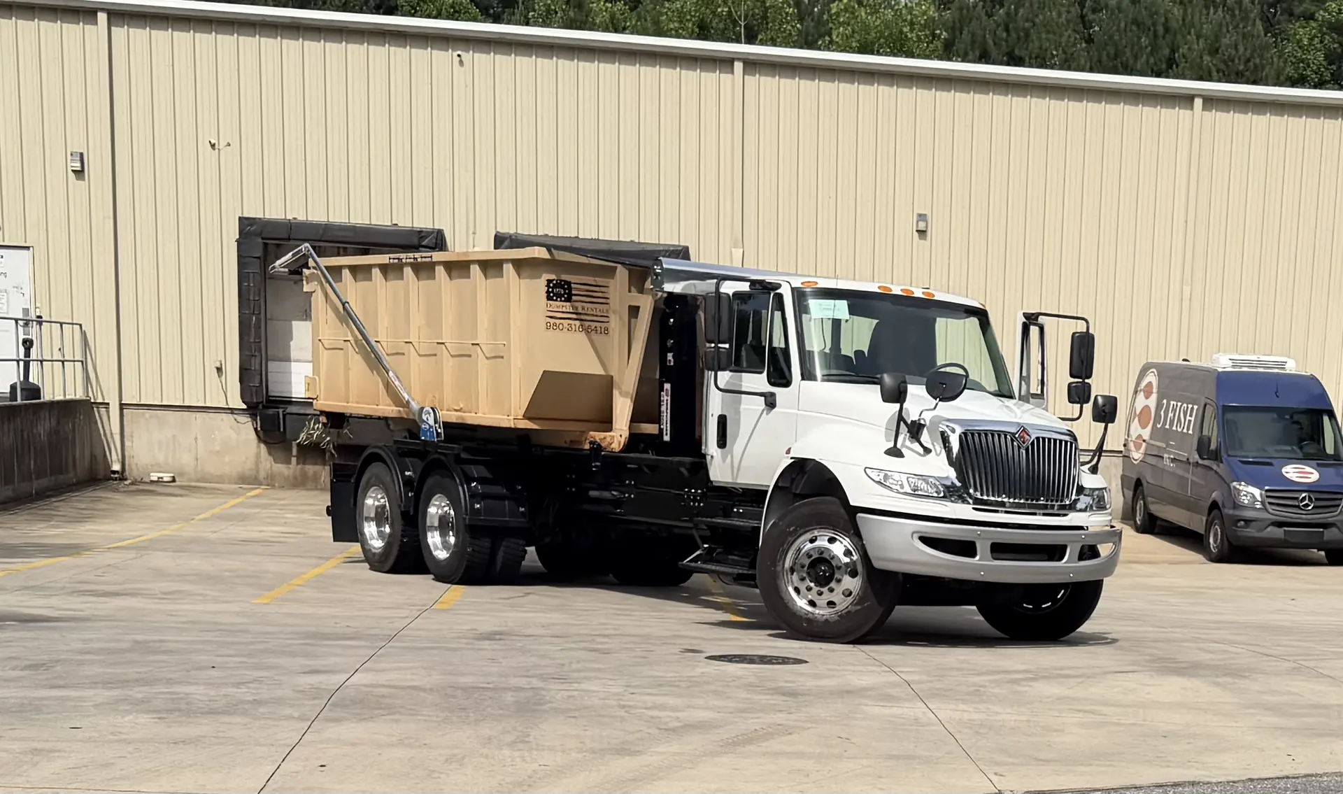 1776 Dumpster Rentals truck carrying a roll-off dumpster
